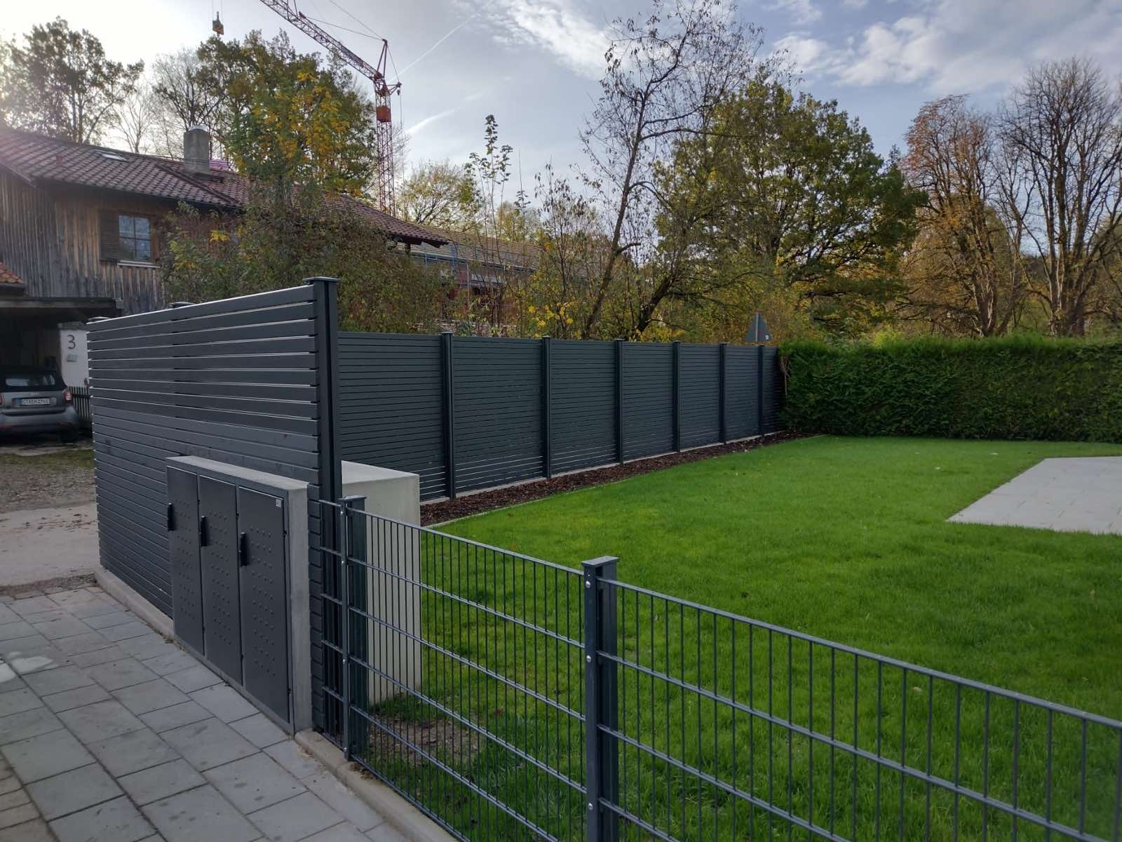 Doppelstabmattenzaun mit Sichtschutz und Mülltonnenbox vor frischem Rasen